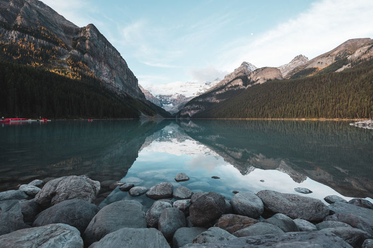Scenic view of lake by mountains against sky