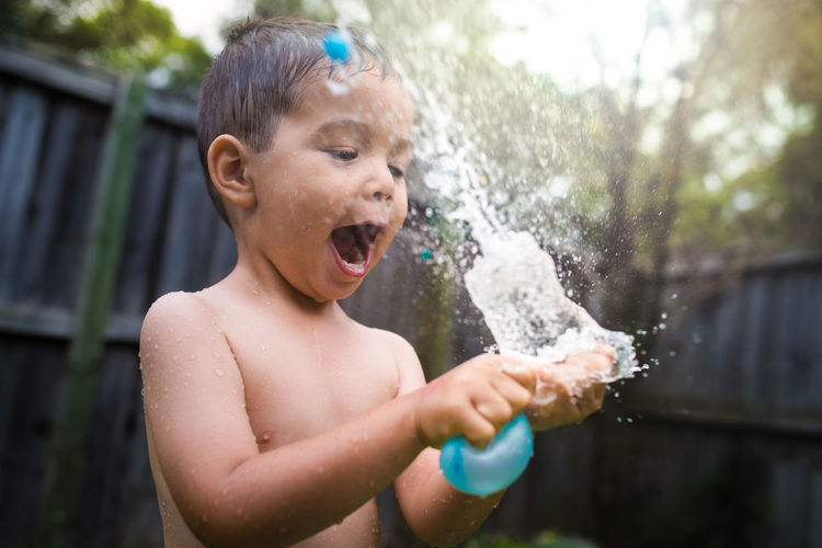 Close-up of shirtless boy splashing water