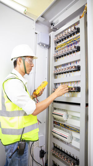 Electrician engineer work tester measuring voltage and current of power electric line