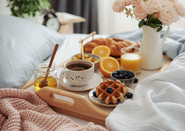 Romantic breakfast with coffee, croissants and rose flowers.