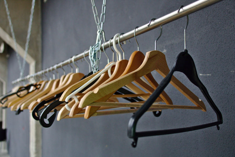 Close-up of clothes hanging on metal against wall
