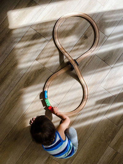 A toddler playing with toys train on the floor