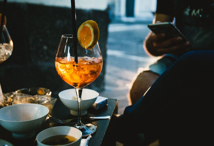 Alcohol Aperol Spritz Close-up Cocktail Drink Drinking Glass Food Food And Drink Human Body Part Human Hand One Person Outdoors People Real People Refreshment Spritz Table The Street Photographer