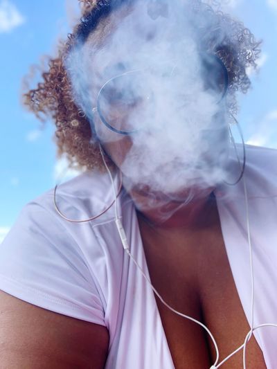 Low angle view of man smoking against sky