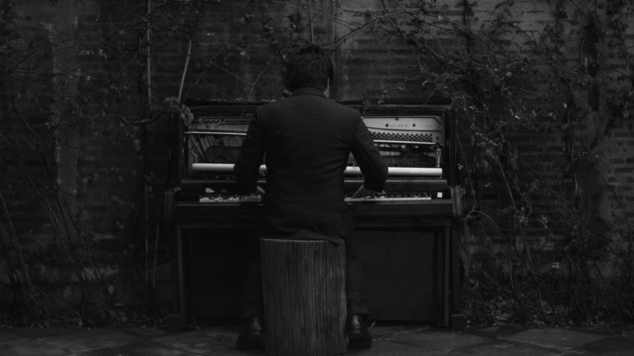 Rear view of a man playing the piano