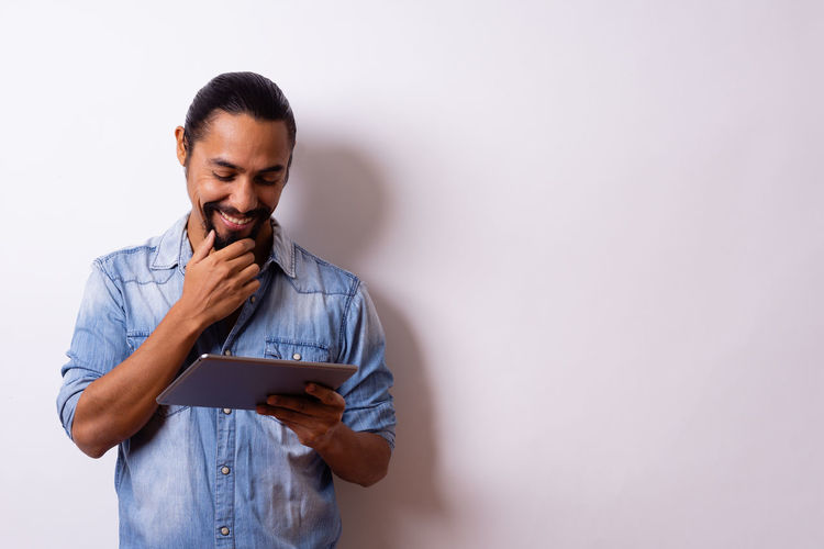 Young man using smart phone against white background