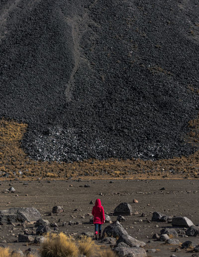 Rear view of woman walking on ground against mountain