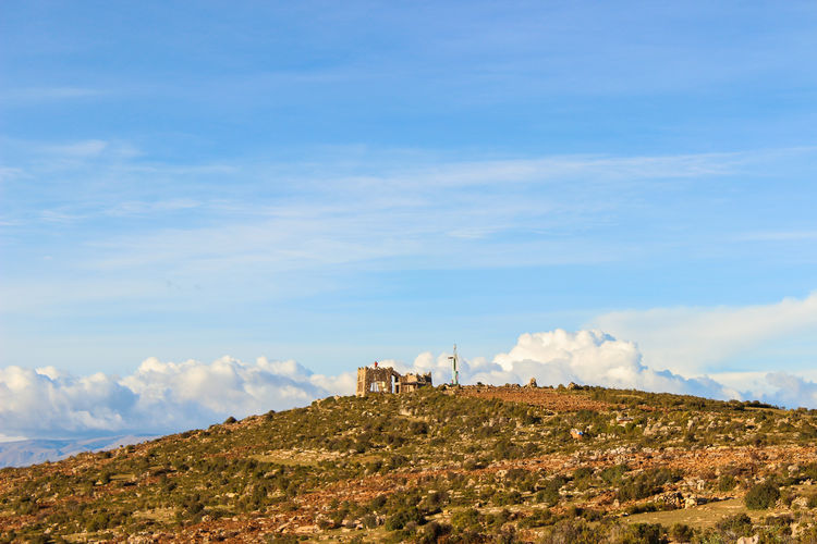 Scenic view of building on mountain against sky