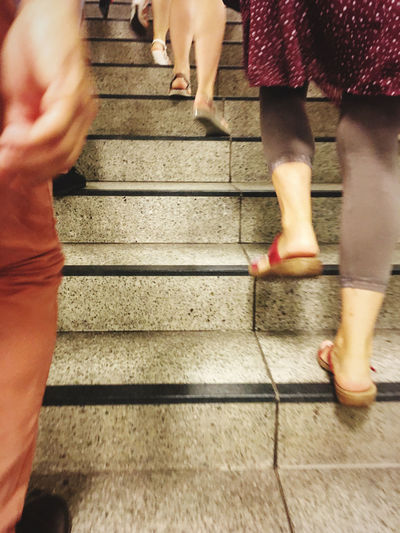 Low section of women walking on staircase