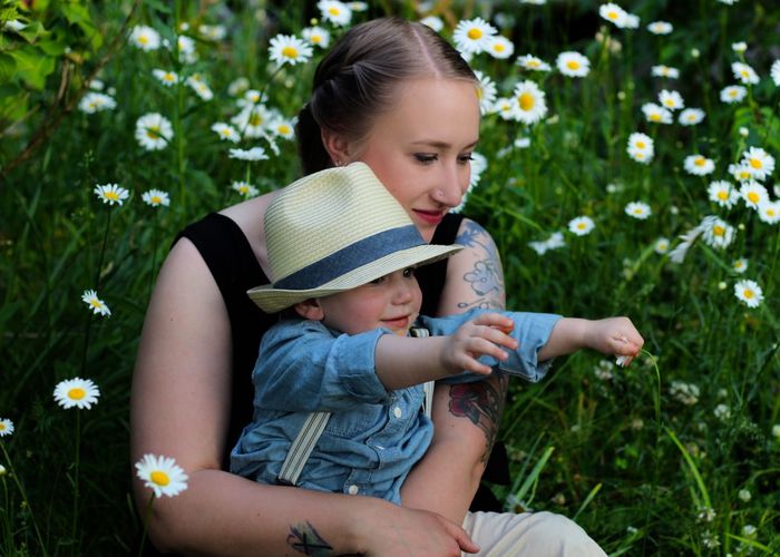 Mother and son sitting in daisies