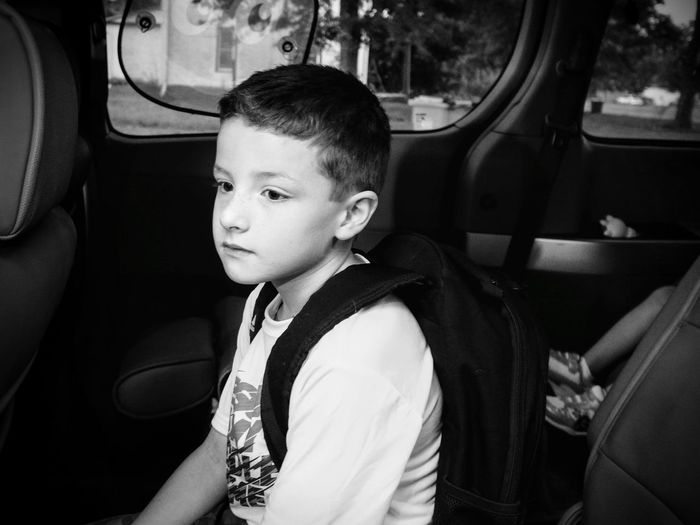 Boy looking away while sitting in car