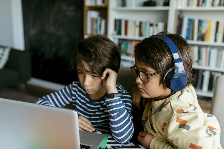 Boys attending homeschooling class through laptop
