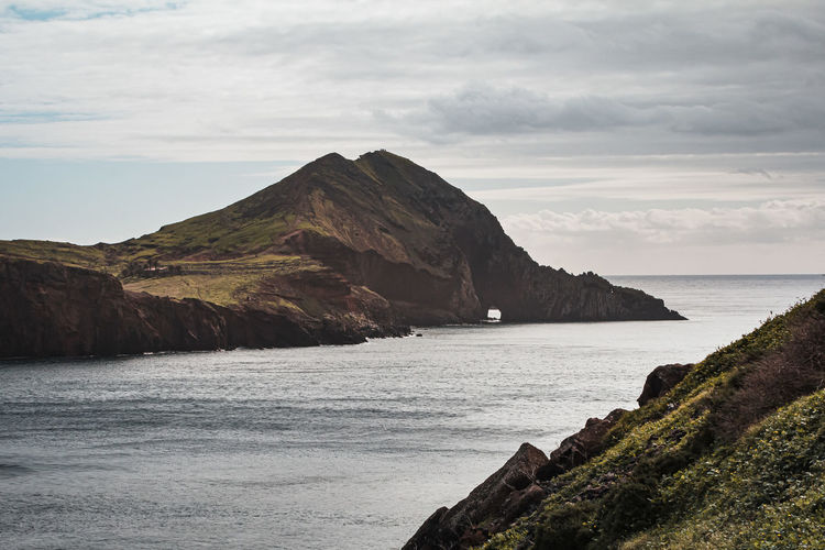 Scenic view of sea and mountains against sky