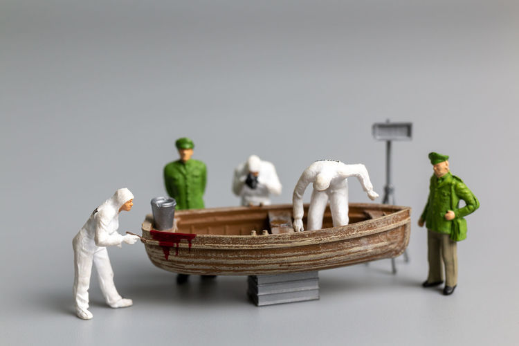 Miniature people police and detective are working on the boat , crime scene investigation concept