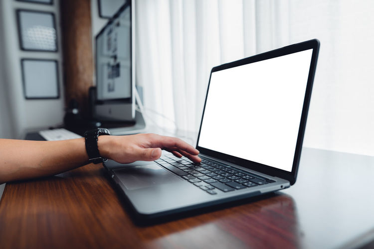 Midsection of woman using laptop on table