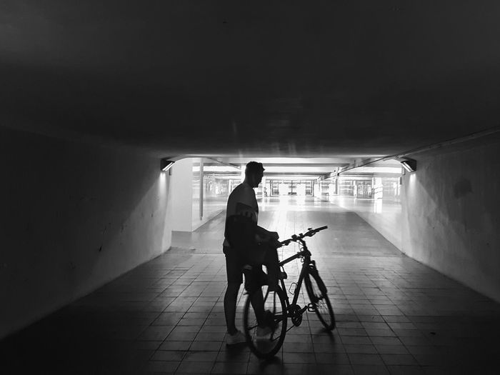 Full length of man riding bicycle in tunnel