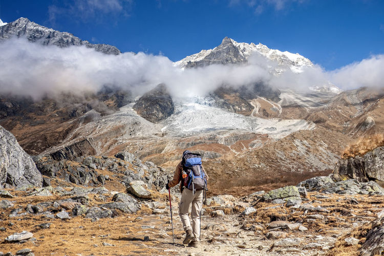 Nepal, hiker at Langtang Valley with Langtang Lirung mountain massif in the background Mountain Hiking Leisure Activity One Person Rock Scenics - Nature Mountain Range Rock - Object Landscape Full Length Beauty In Nature Adventure Exploration Nature Travel Activity Day Sky Outdoors Formation Mountain Peak Nepal Langtang Glacier Lirung