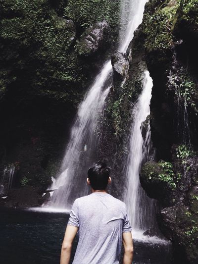 Rear view of woman in waterfall
