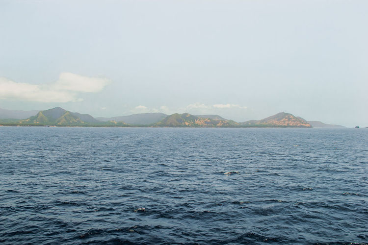 Scenic view of sea and mountains against sky