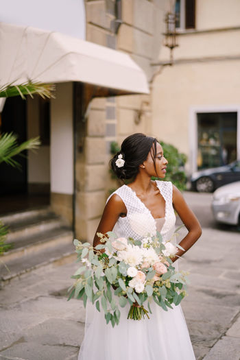 Bride with bouquet looking away outdoors