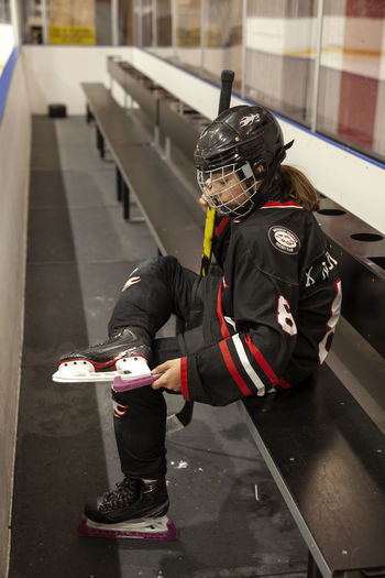 Girl hockey player putting guards on ice skates