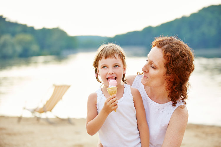 Mother looking at daughter eating ice cream