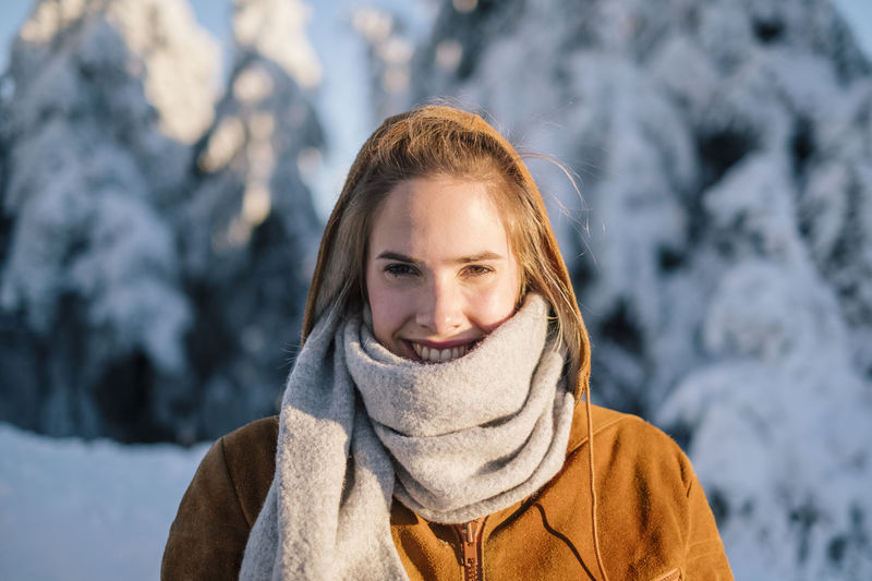 Portrait of smiling young woman wearing warm clothing in winter