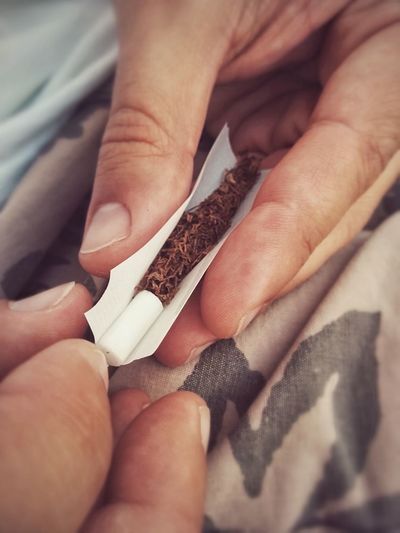 Close-up of hands rolling a joint