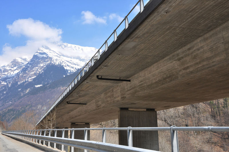 Bridge against snowcapped mountains