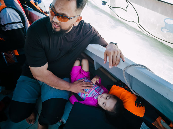 High angle view of man sitting with daughter in ferry