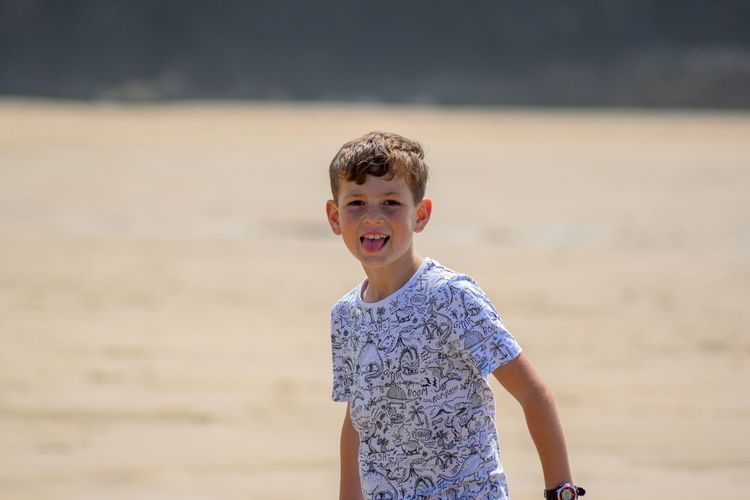 Portrait of smiling boy standing at beach