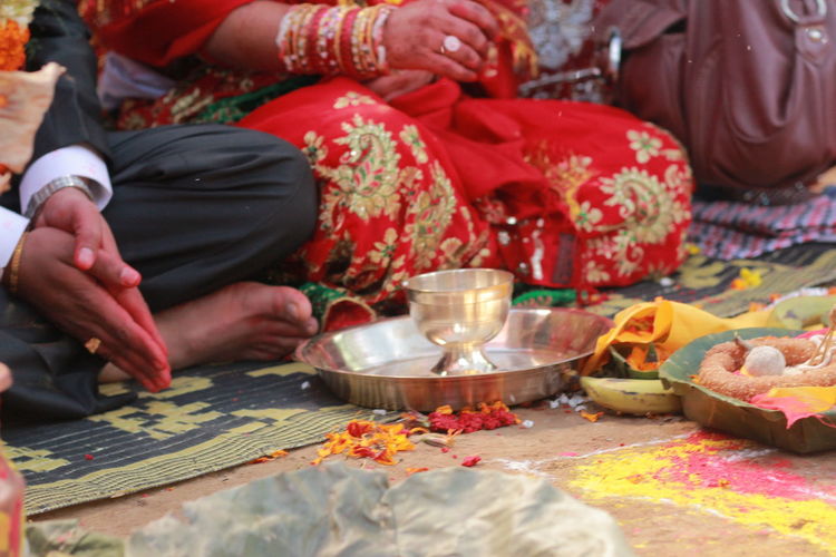 Midsection of bride and groom sitting during wedding ceremony