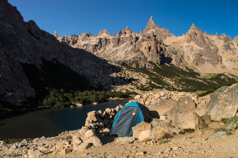 Tent on land against rock mountains