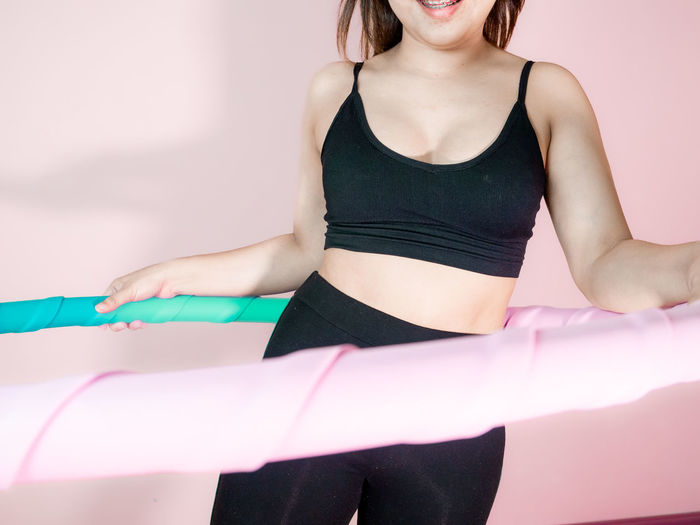 Midsection of young woman exercising at home