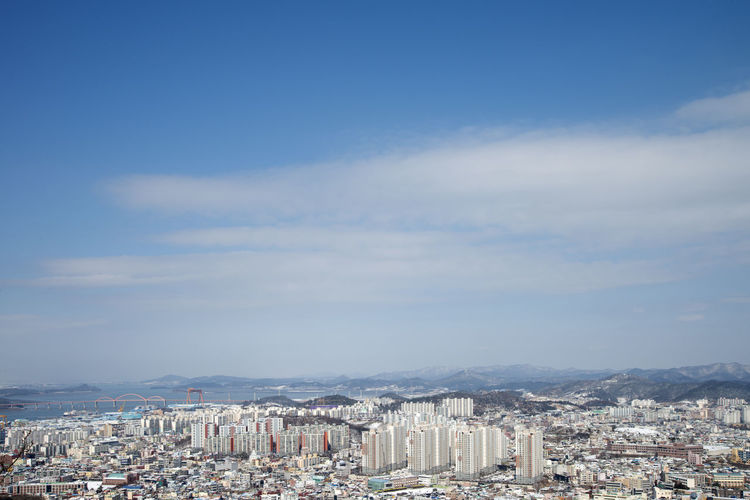 Aerial view of cityscape against blue sky