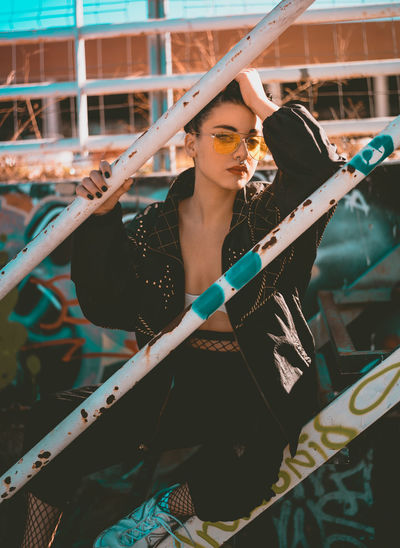 Beautiful fashion model in outdoors Beautiful Woman Day Fashion Front View Full Length Holding Leisure Activity Lifestyles Looking At Camera One Person Outdoors People Portrait Real People Standing Sunglasses Weapon Young Adult Young Women Fresh On Market 2017 This Is My Skin