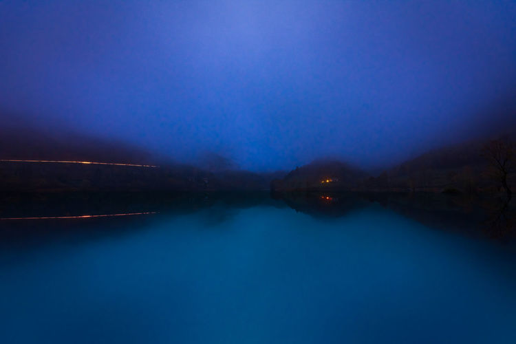 Scenic view of lake against sky at night