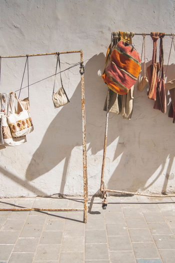 Clothes drying on rope against wall during sunny day