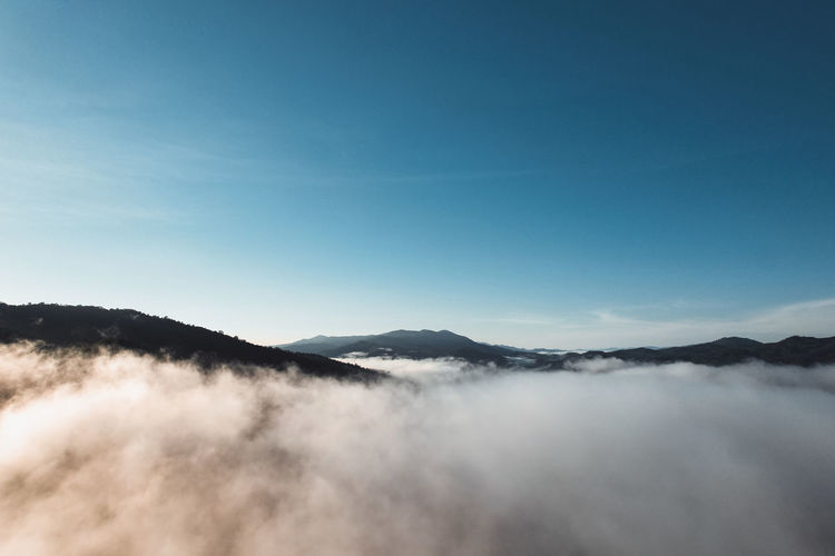 Scenic view of mountains against blue sky