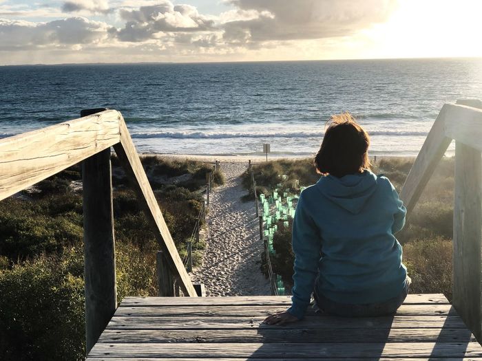 Rear view of woman looking at sea against sky