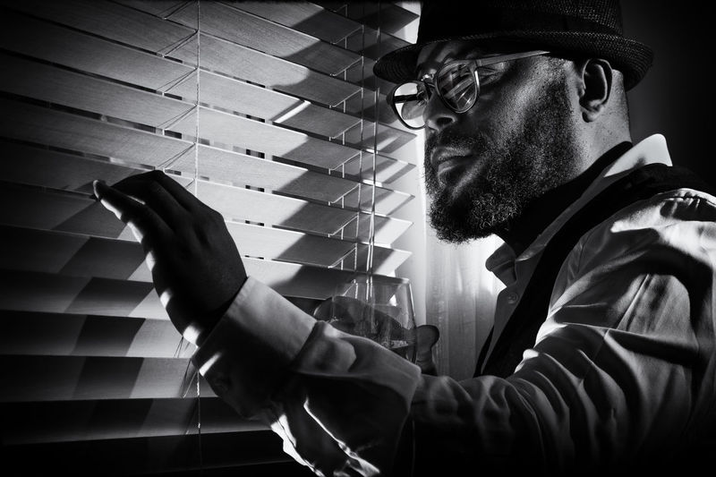 Close-up of man looking through window