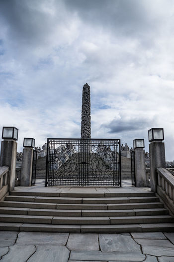 Steps by gate of vigeland sculpture park against sky