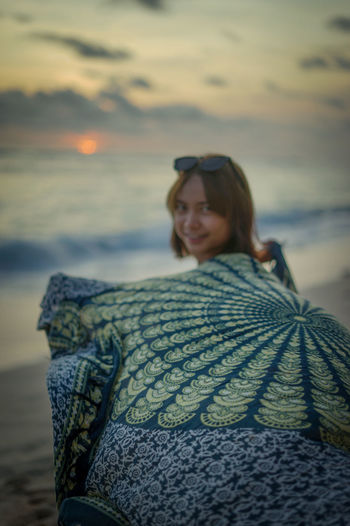 Smiling woman on beach during sunset