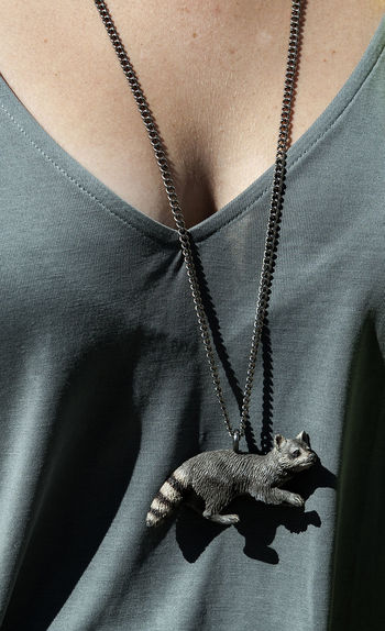 Midsection of woman wearing raccoon necklace