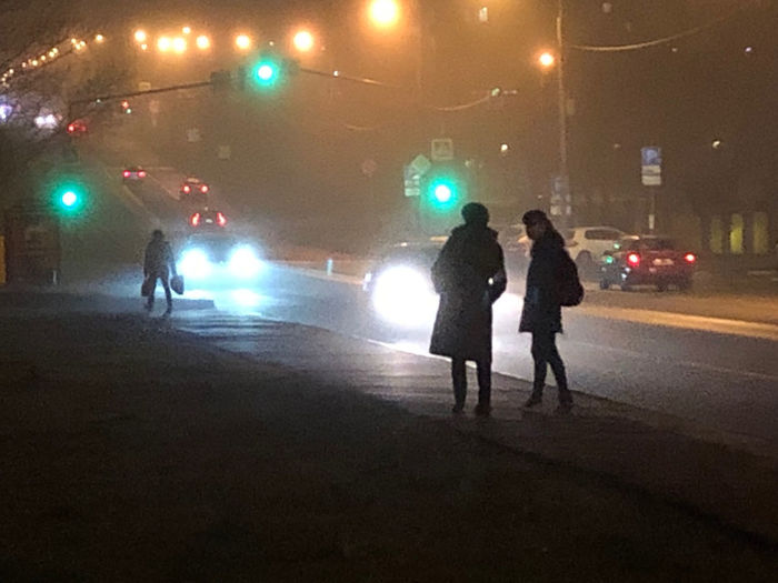 People walking on illuminated road at night