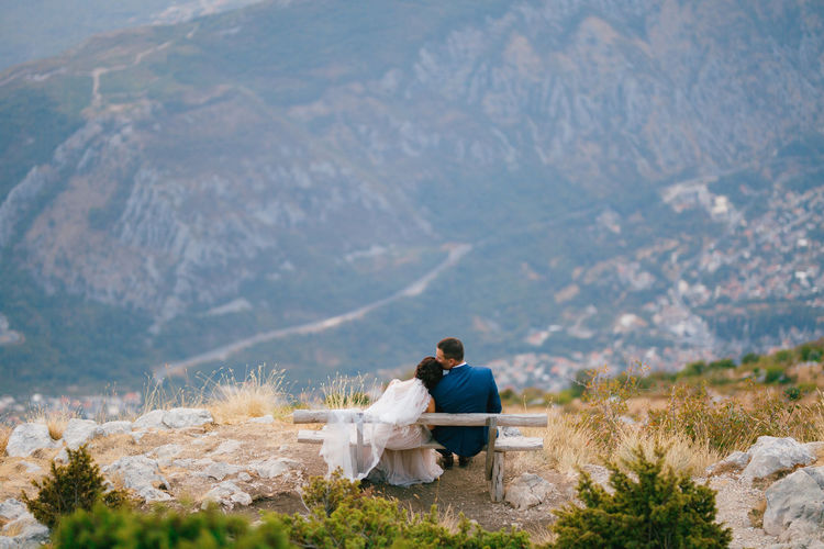 Couple sitting on bench at mountain