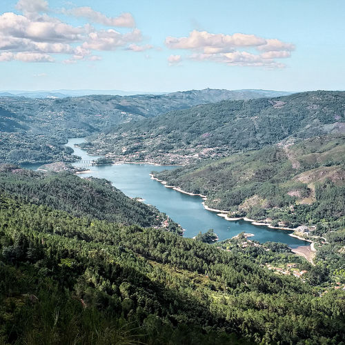 High angle view of trees and mountains against sky and lake