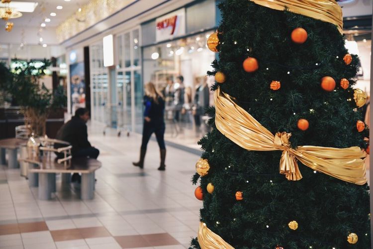 Christmas tree on walkway by shops