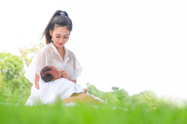 Smiling young woman sitting on field