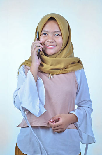 Portrait of a young student asian woman talking on mobile phone, speak happy smile